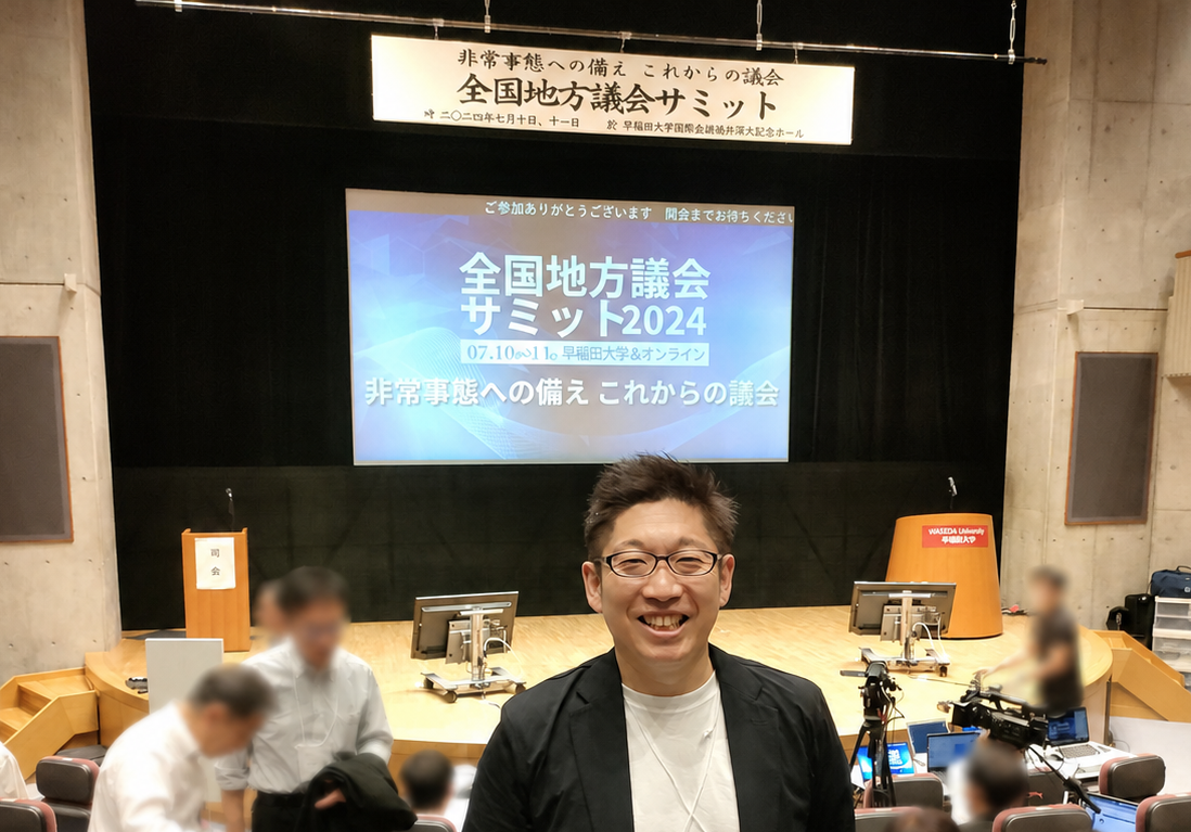 全国地方議会サミットの会場に立つ楠目しんいちろう